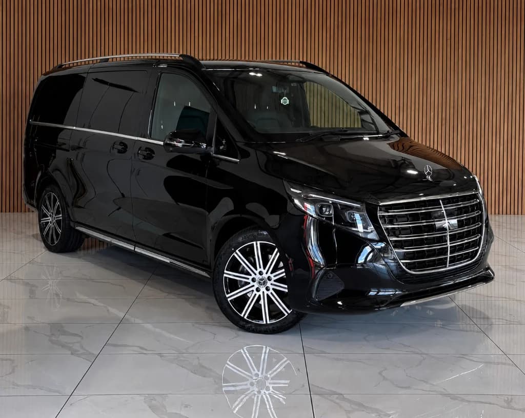 Glossy black Mercedes-Benz V-Class luxury MPV with chrome grille in a showroom